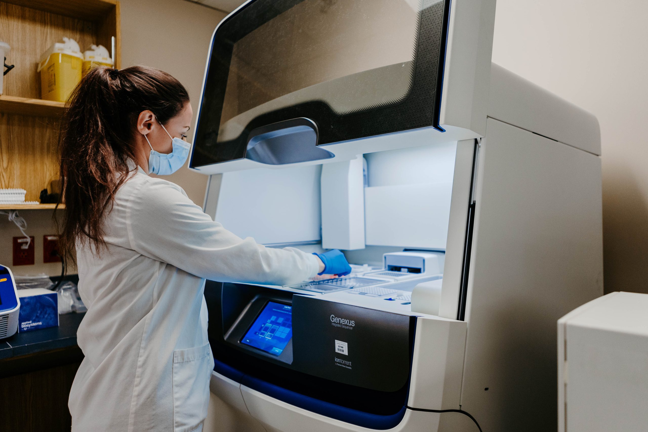Renata Yehia, acting supervisor in Molecular Diagnostics and Cytogenetics loading panels into the Genexus machine to prepare for a run of tests.